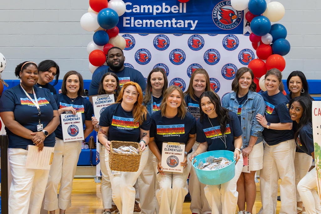 Group of 14 staff members in matching navy blue shirts waiting to talk to job seekers.