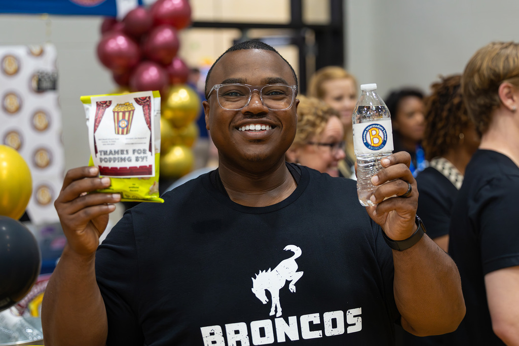 Principal holding up snacks and water.