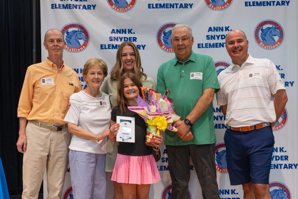 Family with student holding award plaque and candy bouquet.