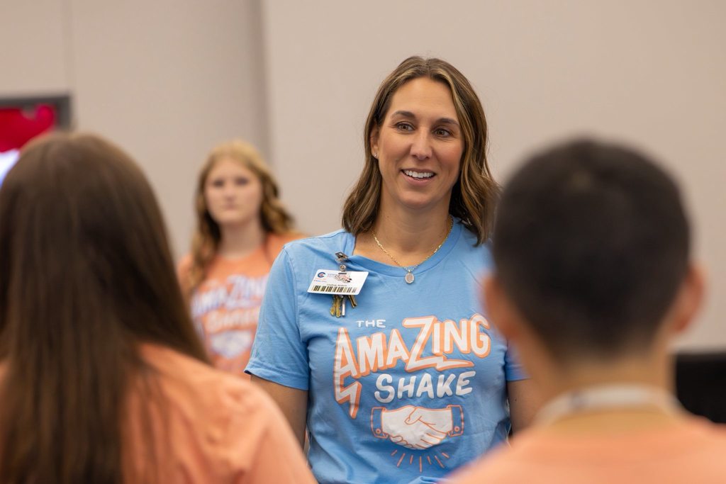 Principal interacts with students at an event.