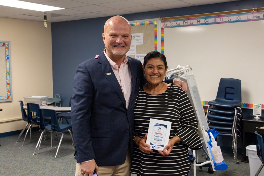 Superintendent with staff member holding award plaque.