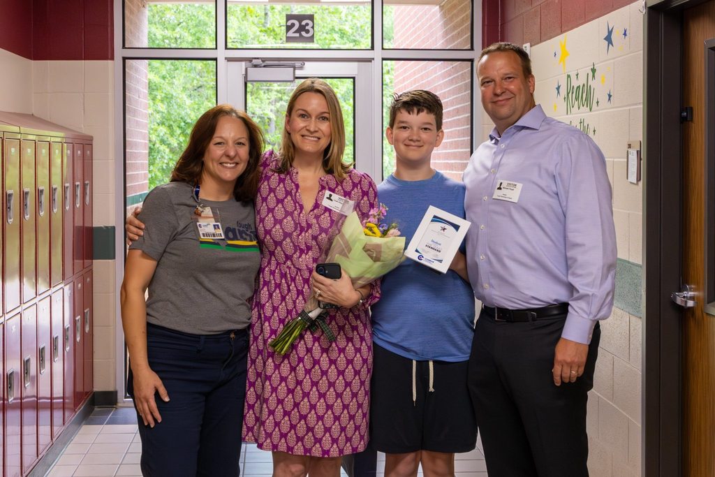 Student with award plaque joined by family.