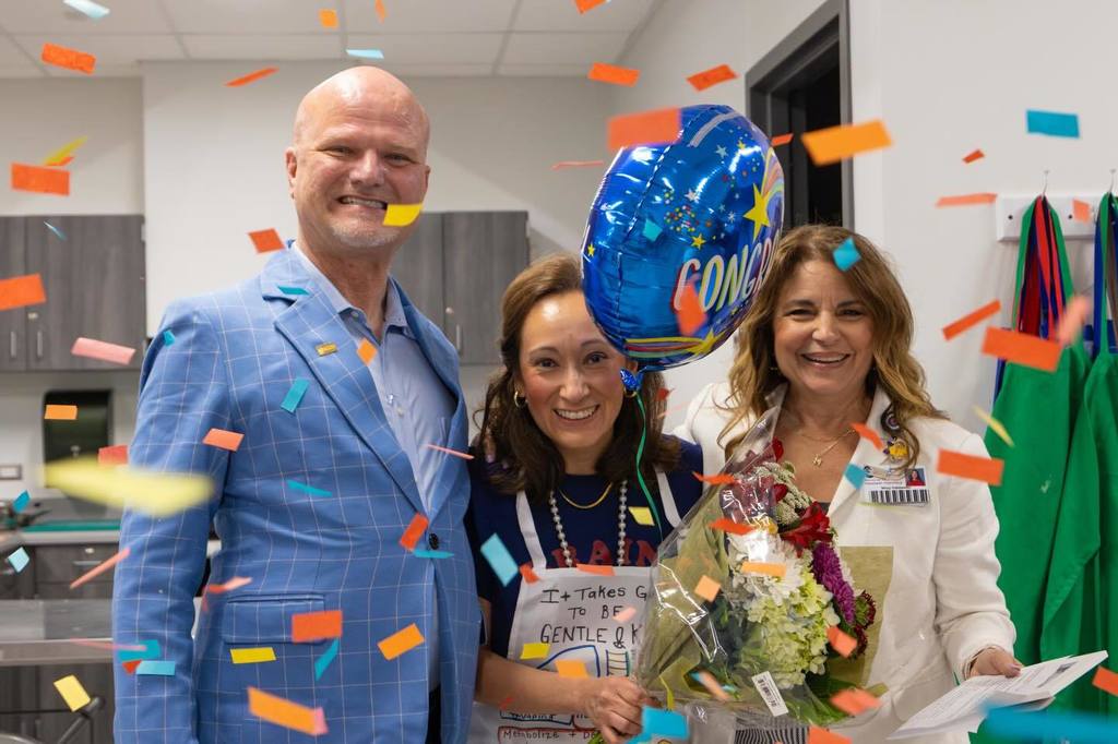 Superintendent and Board President congratulate staff member.