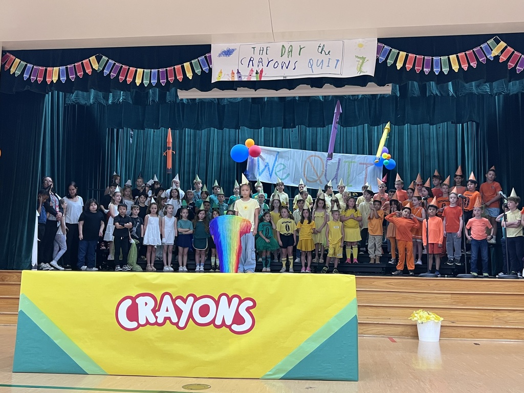 kids on stage with one in front with a rainbow scarf fan