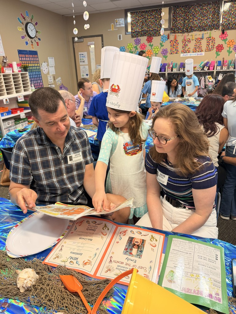 A first grader shares  a book with her family