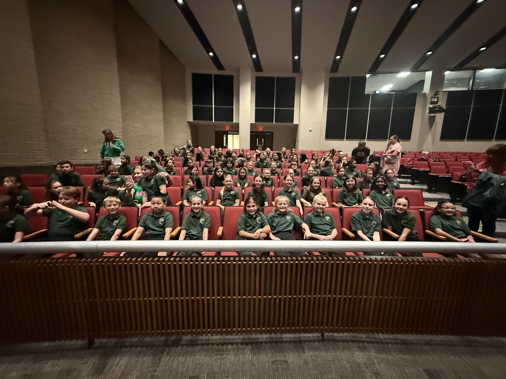kids sitting in auditorium chairs