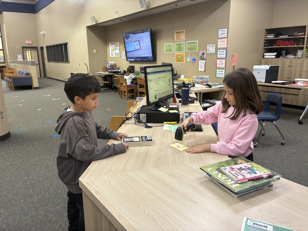 2 children one scanning a library card