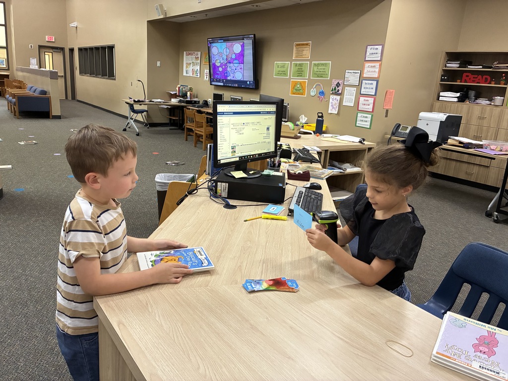 2 children one scanning a library card