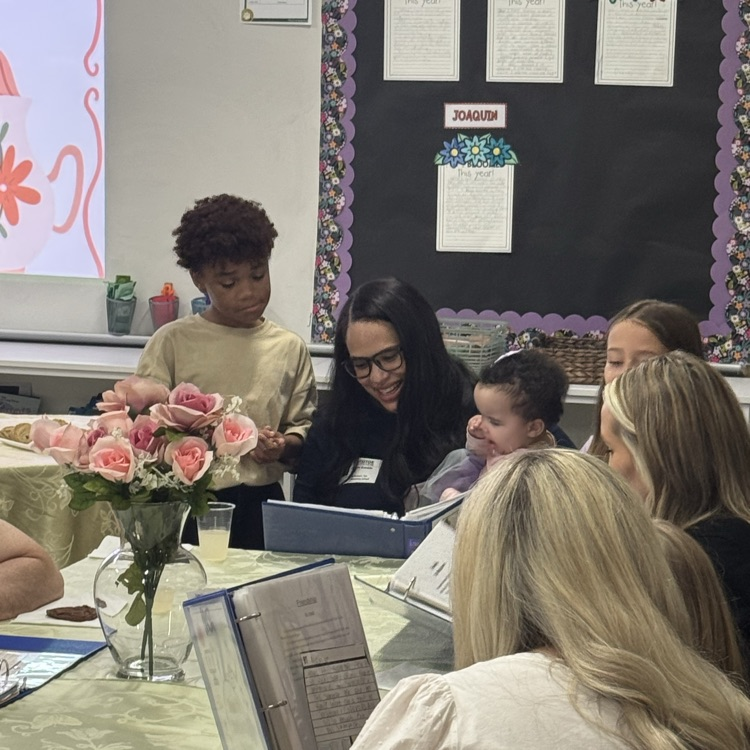 families looking at writing in classroom