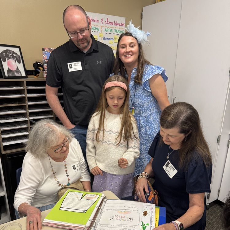 family looking at writing with daughter