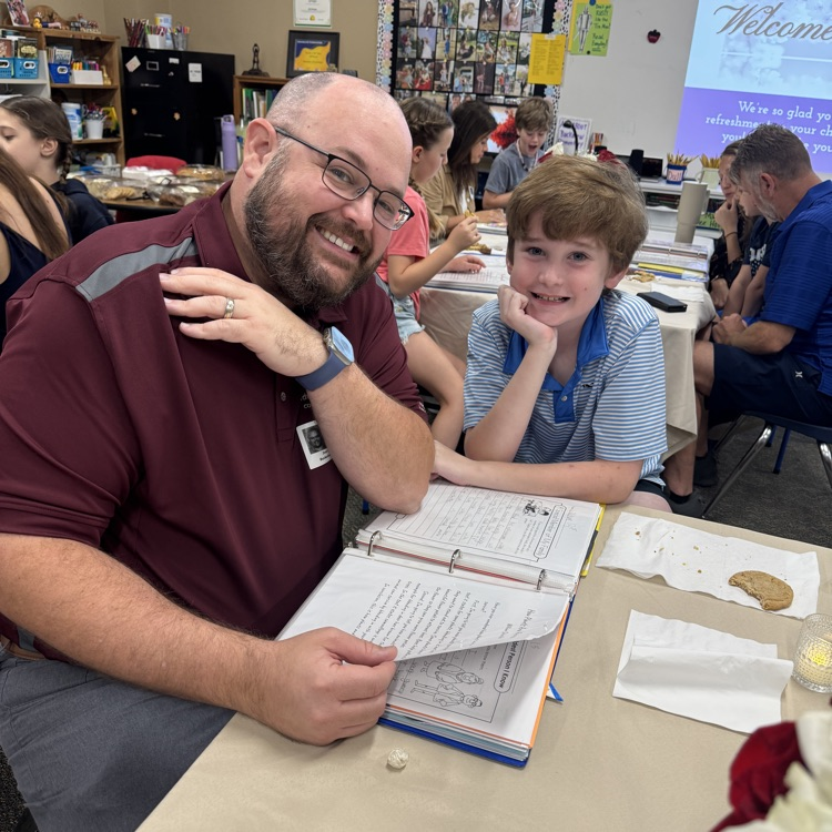 father and son looking at writing
