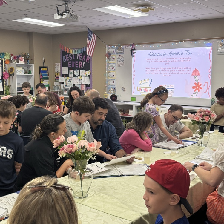 classroom full of families looking at writing binders 