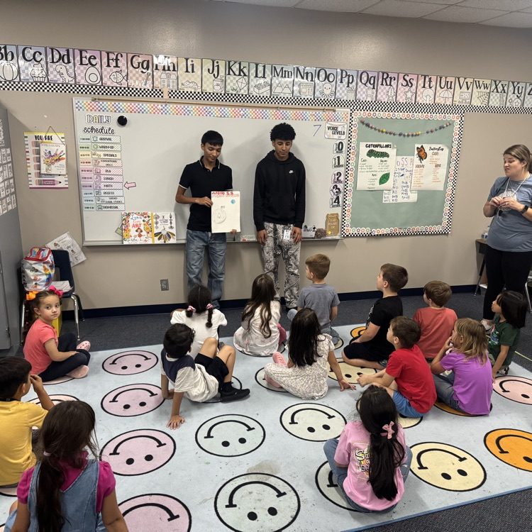 history students read books to elementary kids