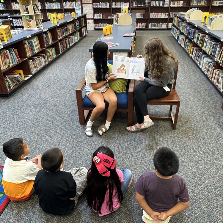 history students read books to elementary kids