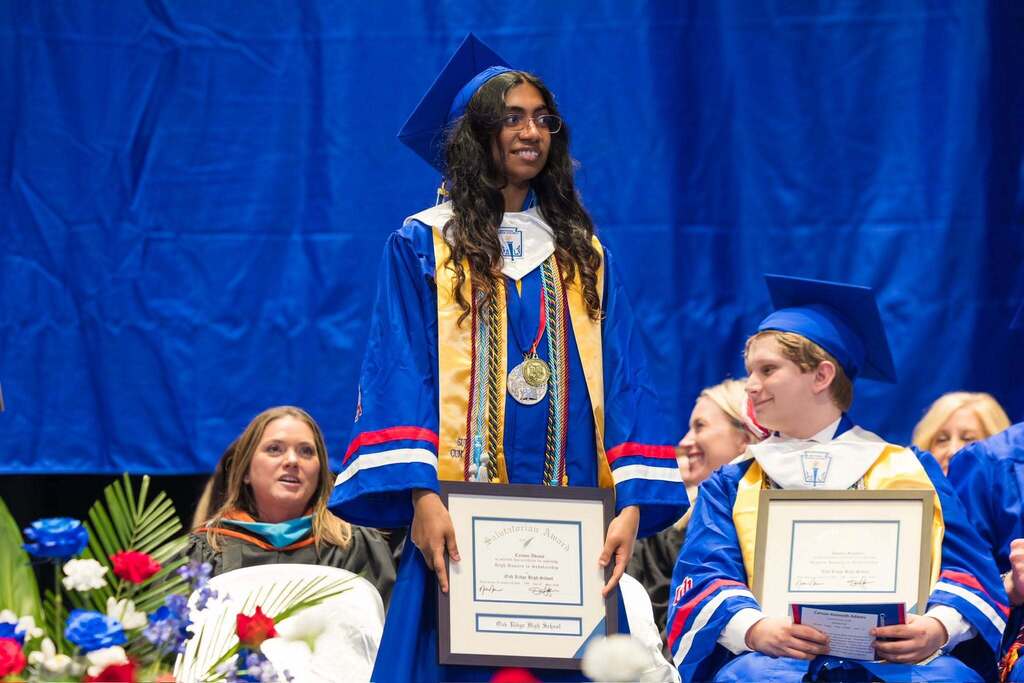 Saludatorian holds plaque while being recognized.