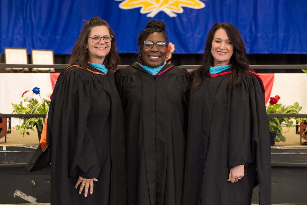 Three principals in black graduation robes.