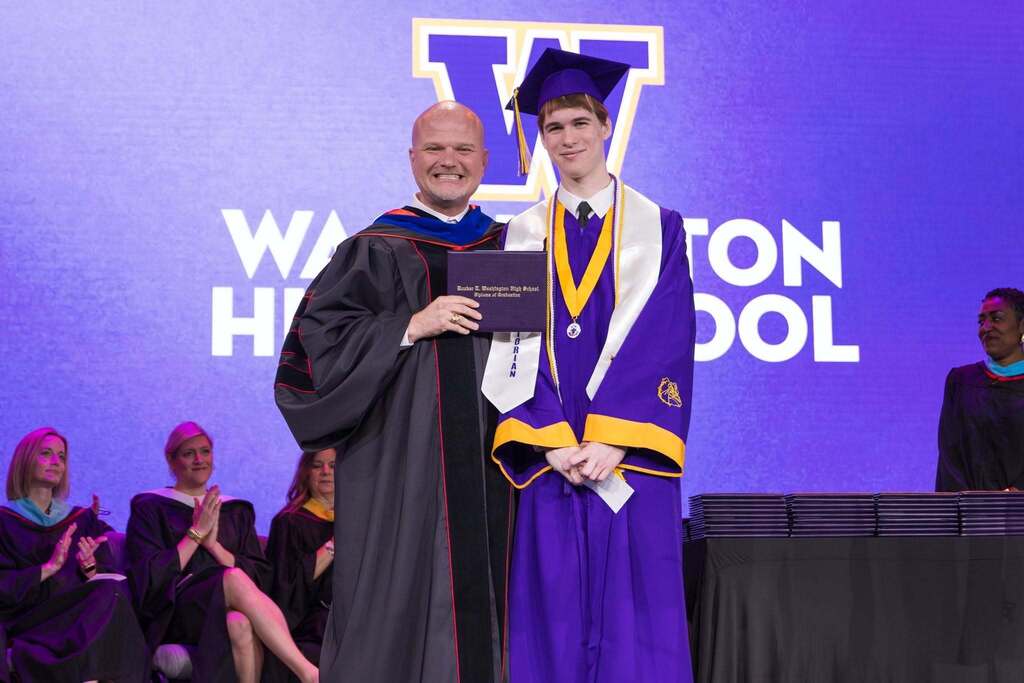 Valedictorian and Superintendent with diploma.