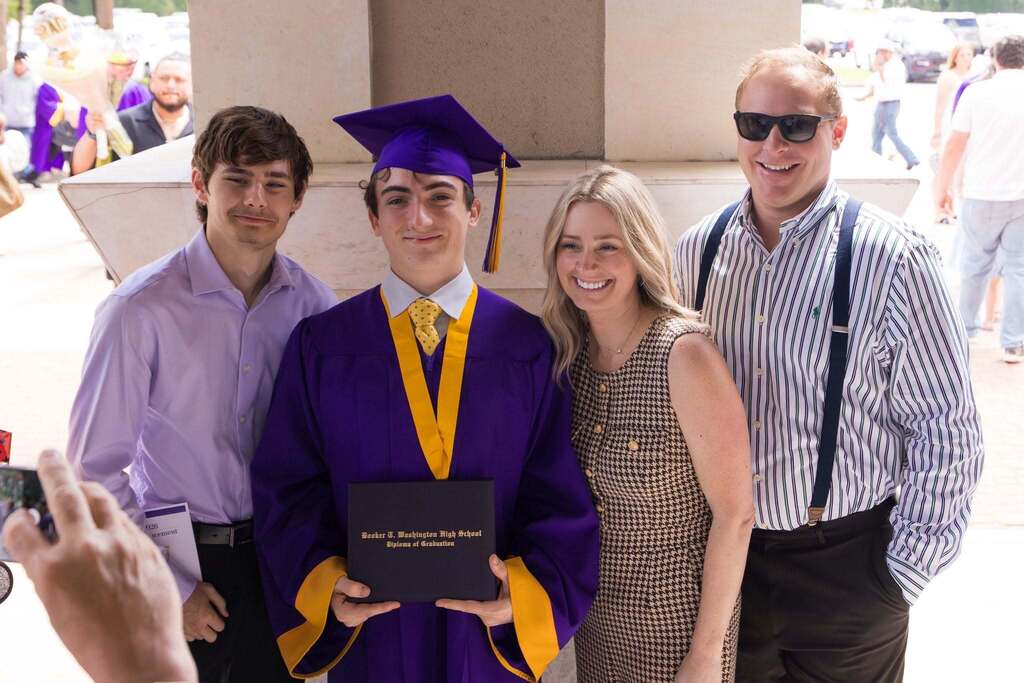 Graduate in purple robe with family.