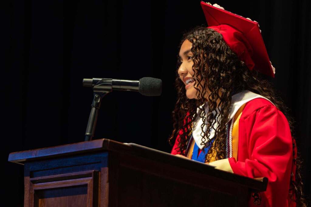 Female student gives speech at graduation.
