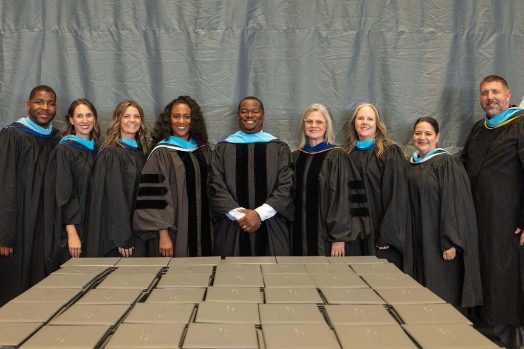 Grand Oaks feeder principals in black graduation robes.