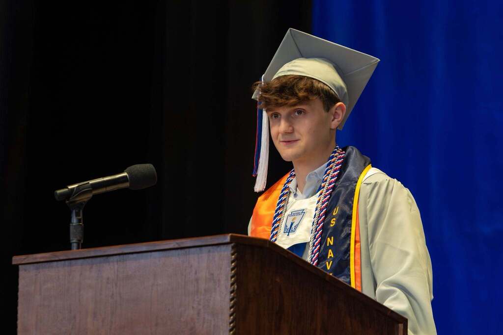 Male student gives a speech at graduation.