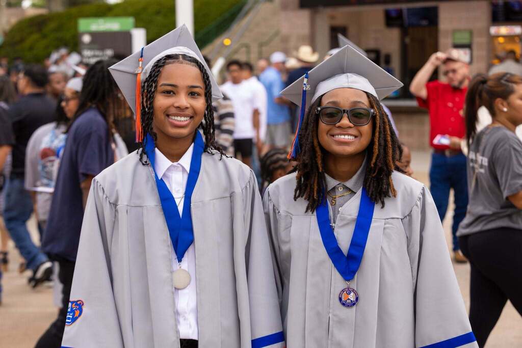 Two graduates  in gray caps and gowns.