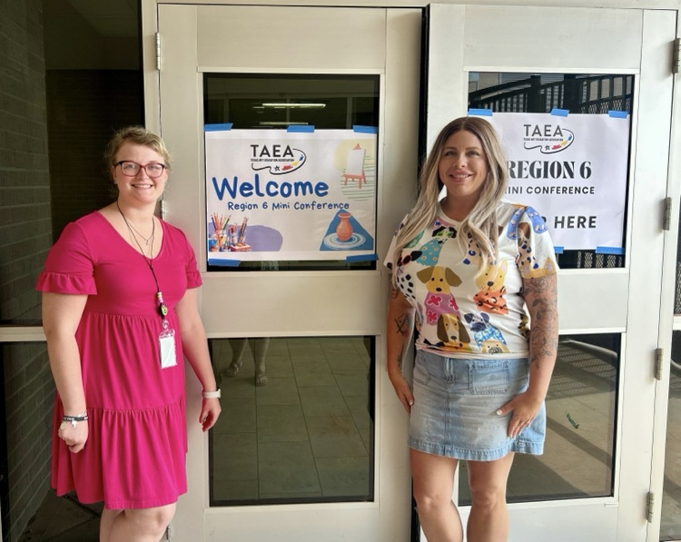 two teachers standing outside a door
