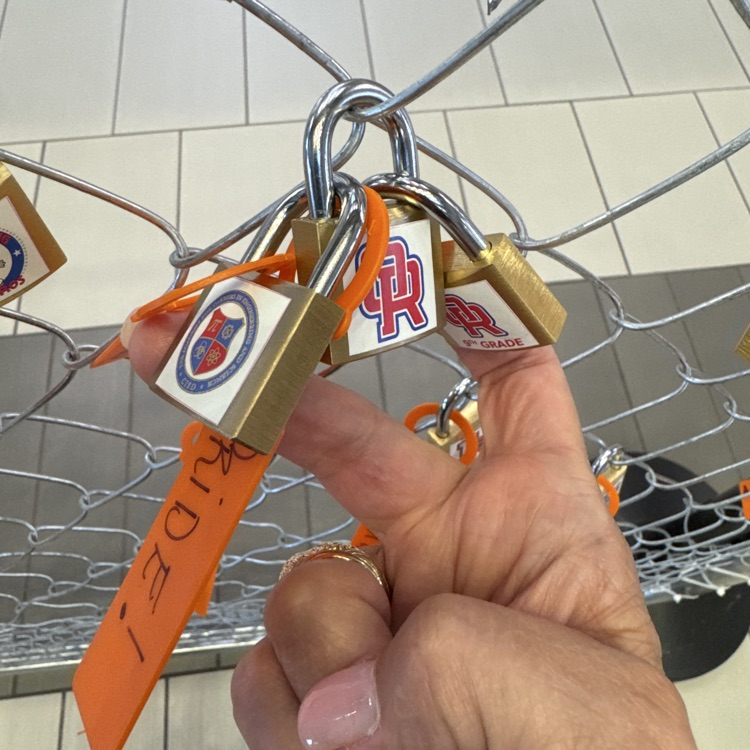 3 locks intertwined ORHS ACES ORHS9 on a fence with orange tags labeled PRIDE