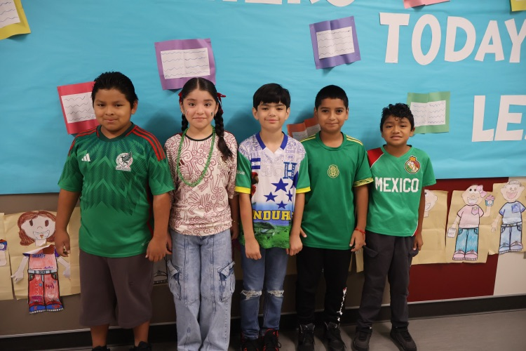 Five students proudly show their Mexican heritage in festive attire and soccer jerseys.