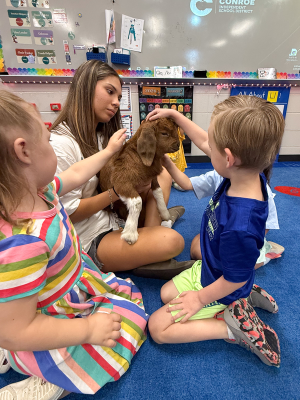 Students in the Education & Training Program with a goat