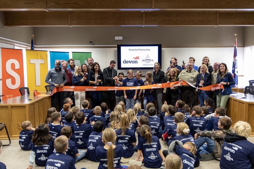 Group of students and adults at a ribbon cutting ceremony