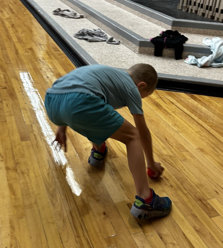 A student picking up a ball