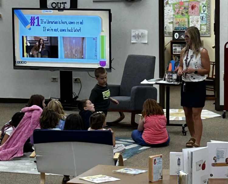 Students listening to the teacher in library