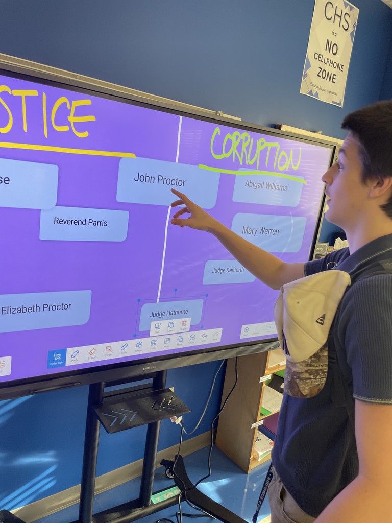 Students interacting with the smart board and sorting characters from the Crucible into Team Justice and Team Corruption.