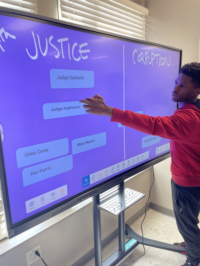 Students interacting with the smart board and sorting characters from the Crucible into Team Justice and Team Corruption.