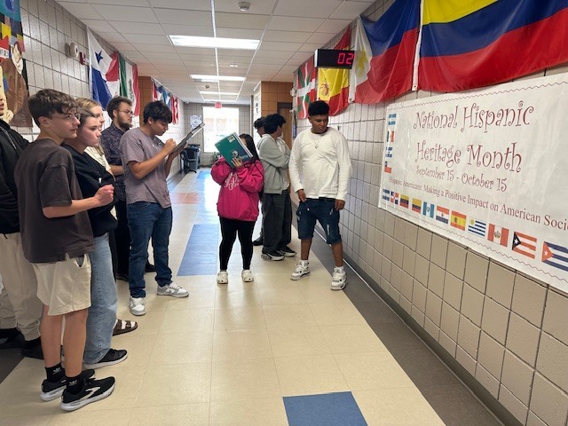 Students gathered around the banner trying to determine which countries are represented.