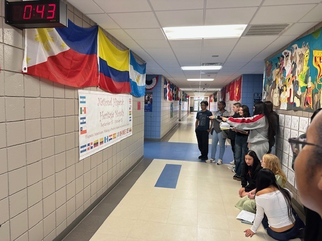 Students gathered around the banner trying to determine which countries are represented.