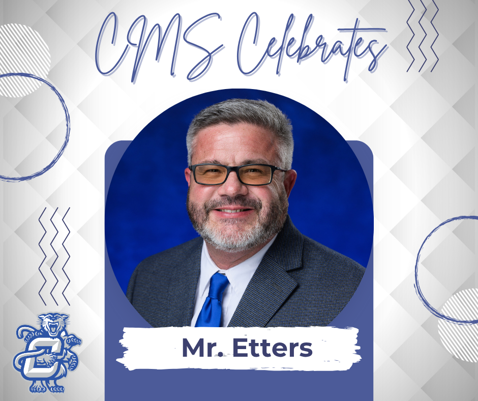 Mr. Etters in a gray suit with a white shirt and blue tie