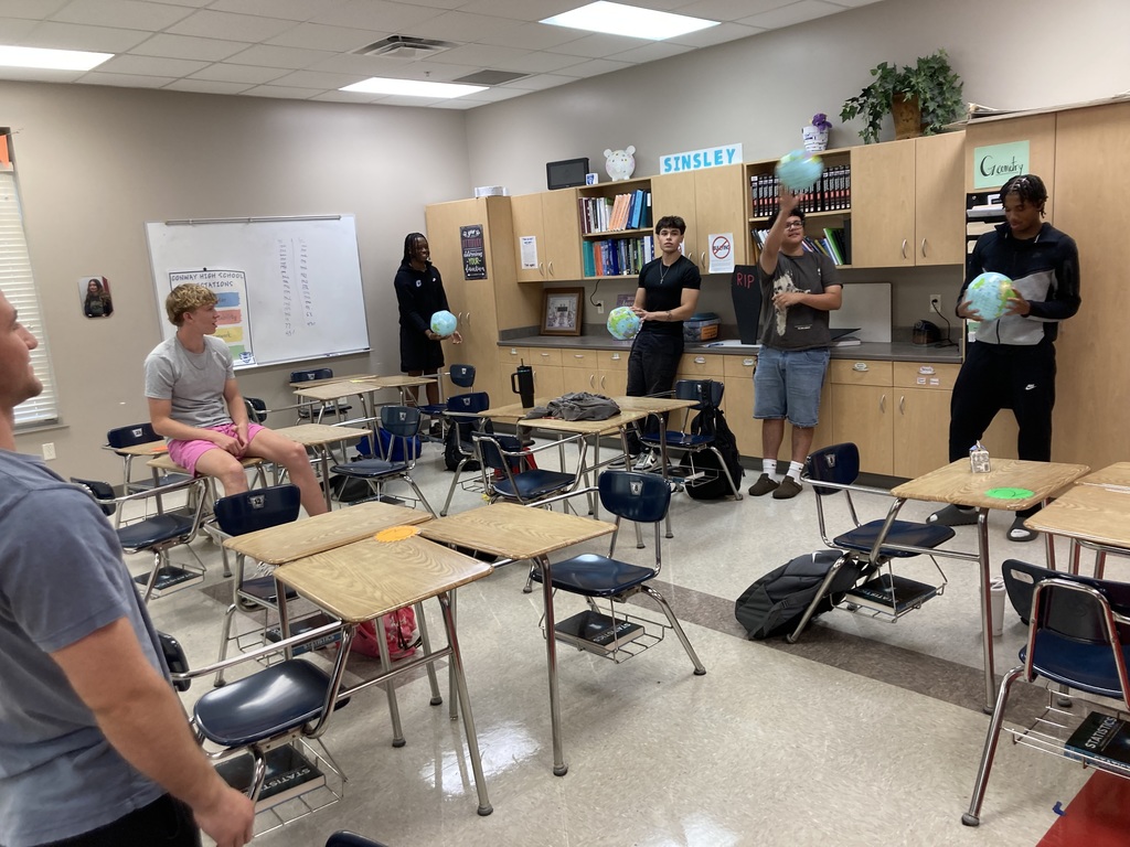 Students toss an inflatable globe to partners.