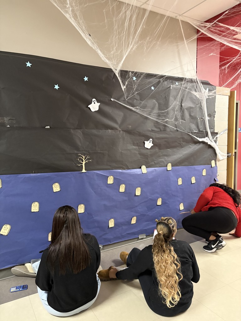 Paper tombstones on a paper graveyard. Students studying the data.