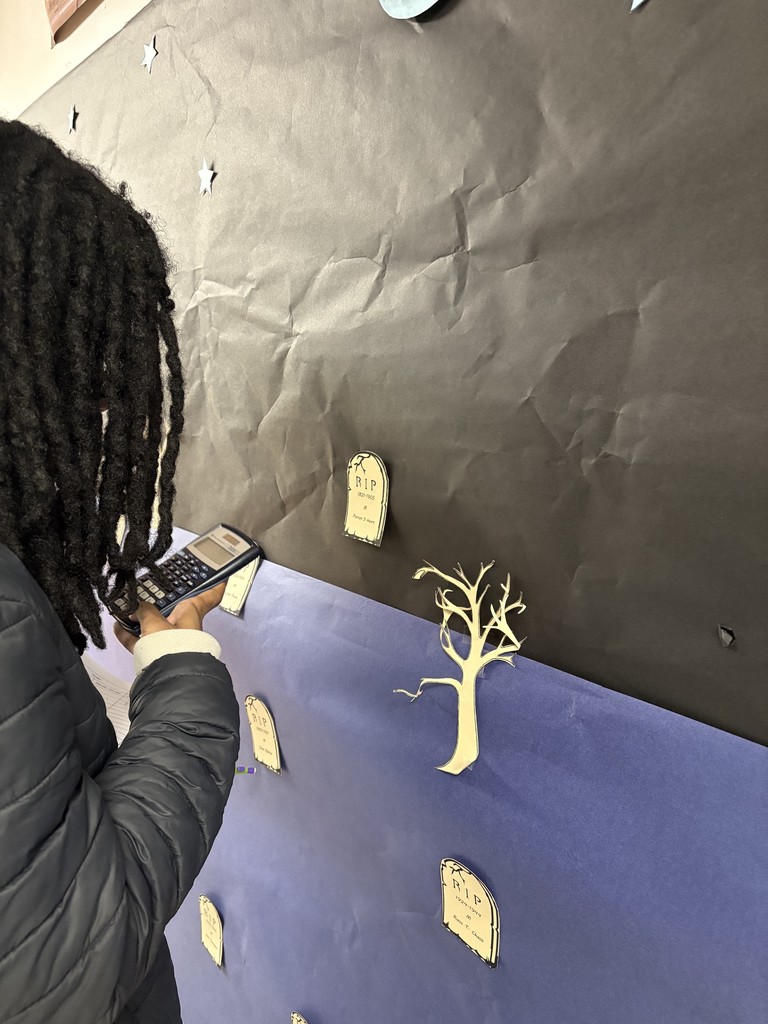 Paper tombstones on a paper graveyard. Students studying the data.
