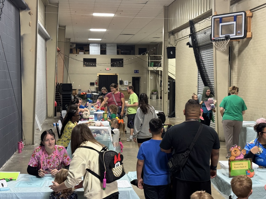 EMR students work with little kids to give their stuffed animals a check up.