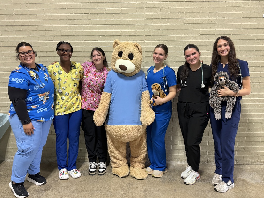 EMR students pose with teddy bear mascot.