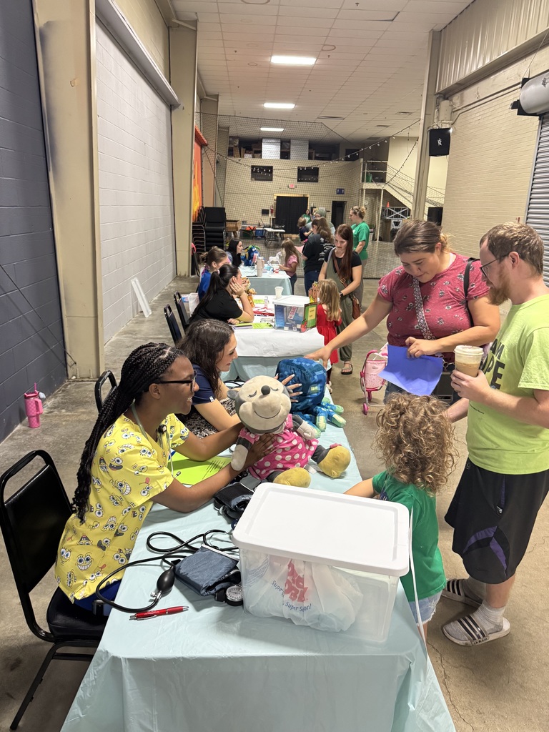 EMR students work with little kids to give their stuffed animals a check up.