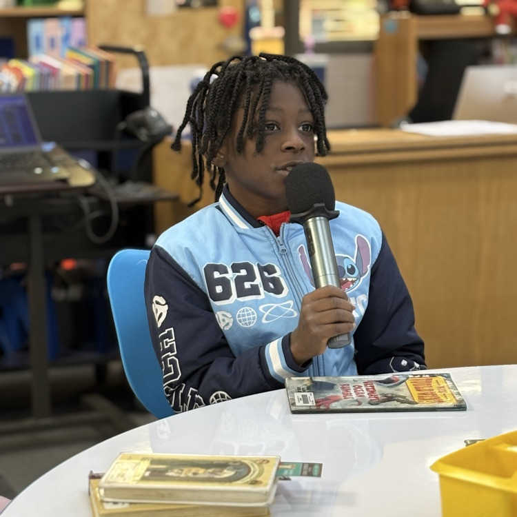 photo of students reading aloud in library 
