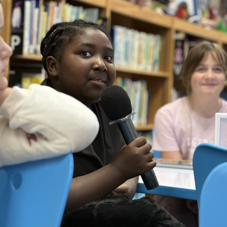 photo of students reading aloud in library 