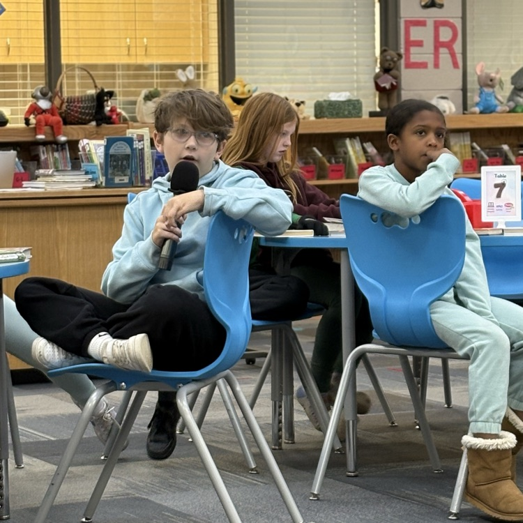 photo of students reading aloud in library 