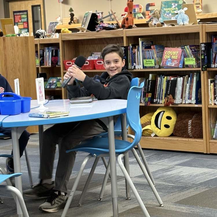 photo of students reading aloud in library 