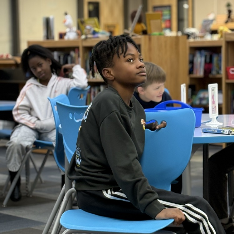 photo of students reading aloud in library 