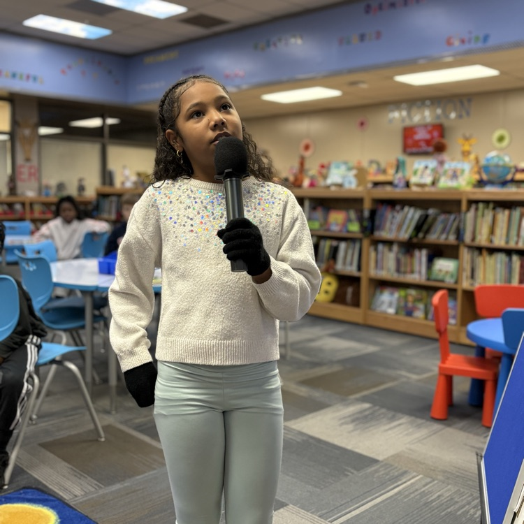 photo of students reading aloud in library 